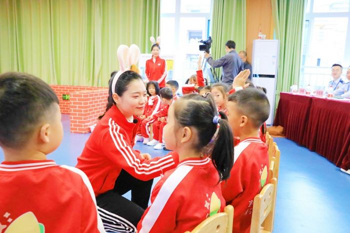 老师与幼儿们做游戏传递消防知识。
