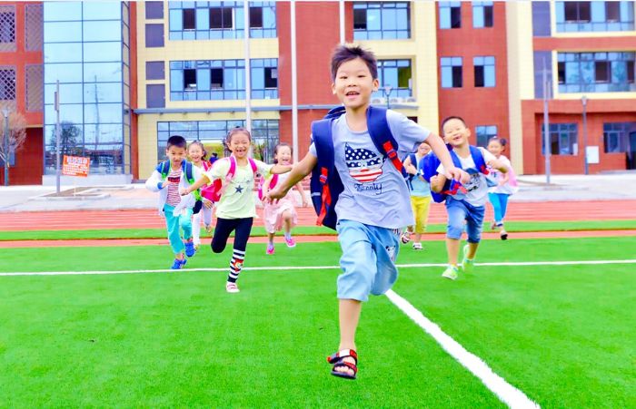 放学了，孩子们竞相跑向操场活动。
