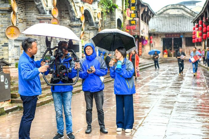 邓雪梅（右一）在双江古镇指导拍摄“双晒”宣传片。
