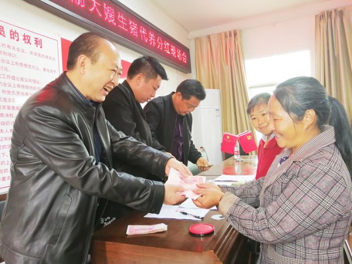 社区贫困户领取“渝大嫂”项目分红。