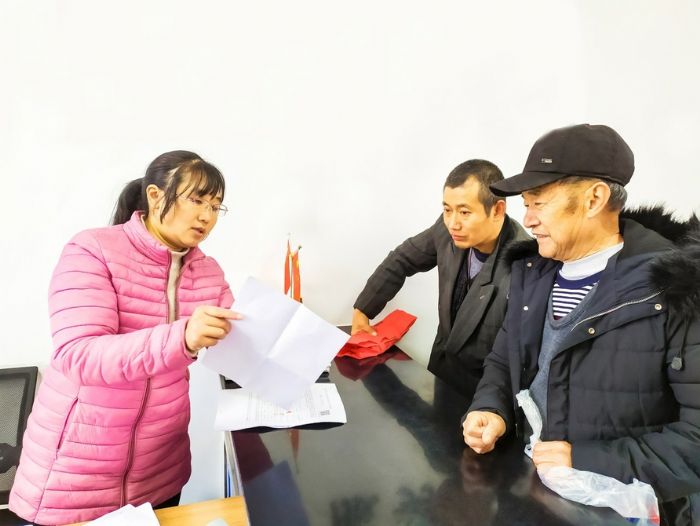 新田社区工作人员耐心向村民讲解办理程序。
