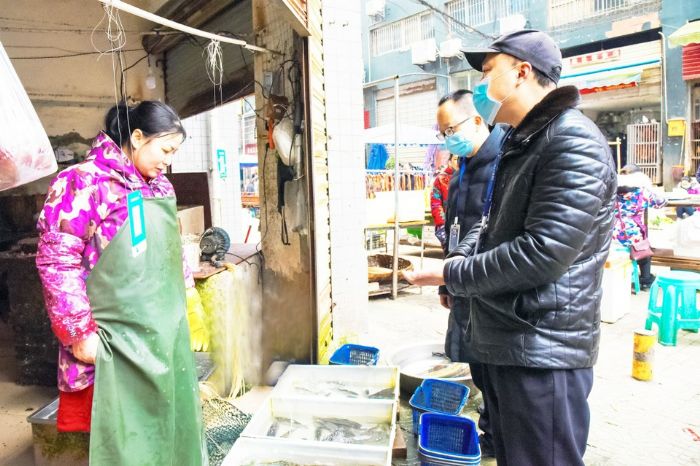 执法人员在莲花农贸市场检查水产品。
