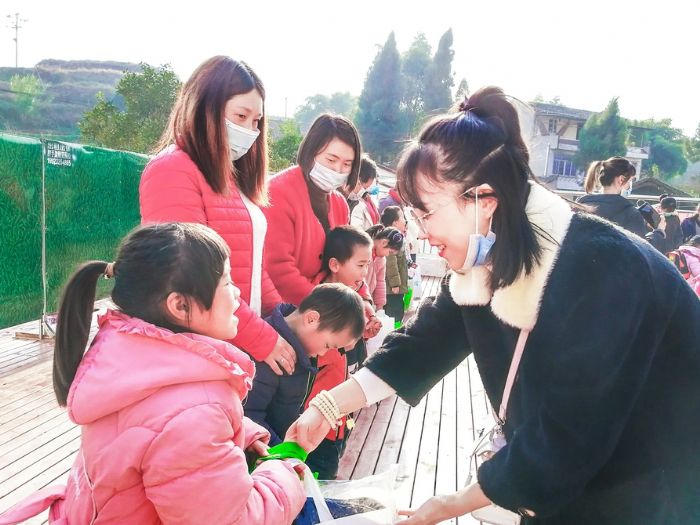 区女企业家商会会员为孩子送上礼包。
