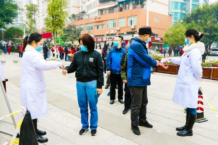 医务人员对市民进行体温检测。
