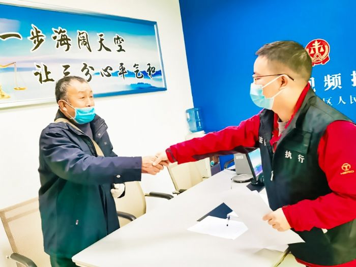 ▶收到工资的农民工唐某对区法院工作人员表示感谢。

