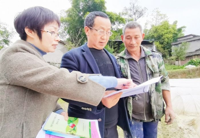 郭礼容（左）给村民讲解农技知识。
