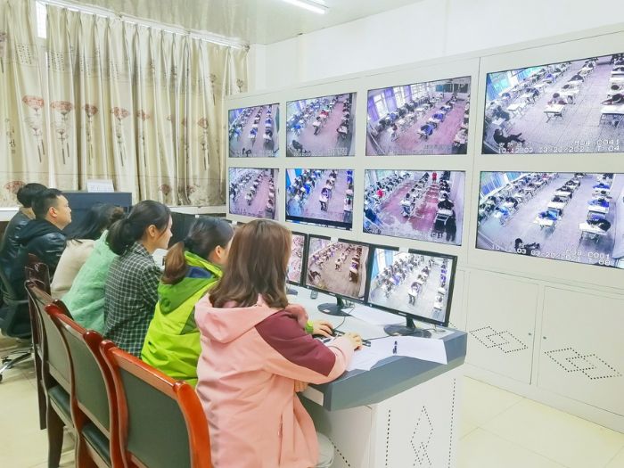 工作人员在电子监控室内监考。
