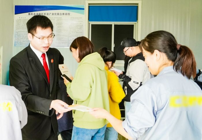 法院干警为企业员工发放宣传册。
