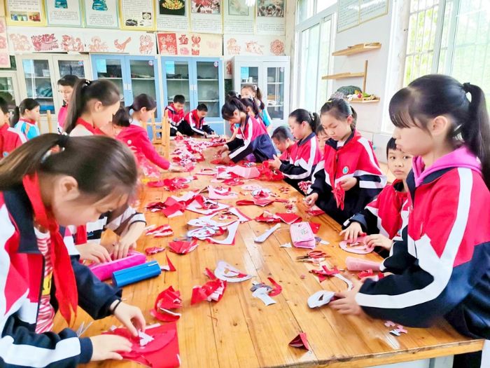 学生们制作红色剪纸作品。

