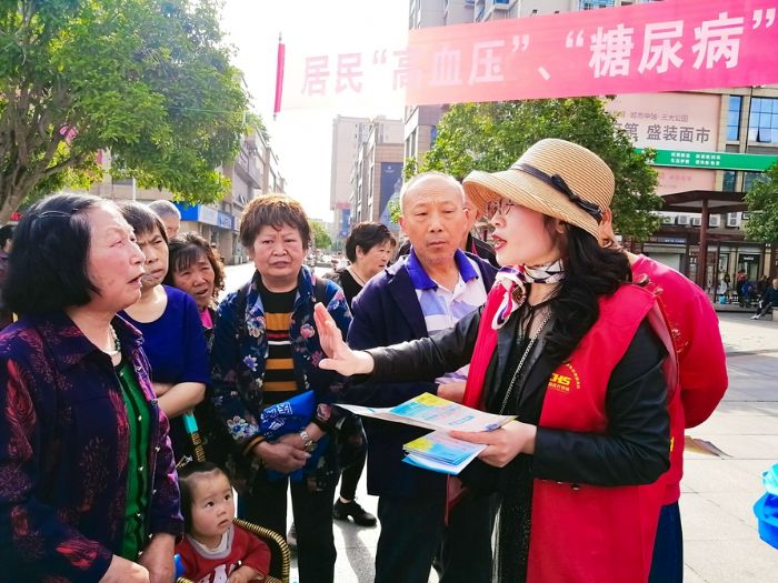 工作人员给居民讲解“高血压”、“糖尿病”门诊用药保障政策。
