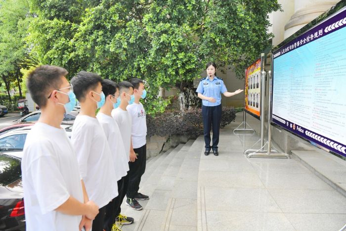 工作人员向学生介绍法院安检流程。
