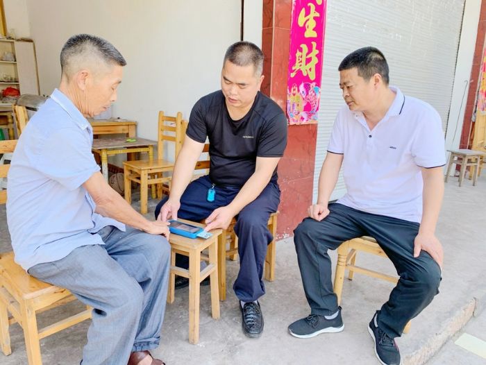工作人员上门为老人办理养老金资格认证。
