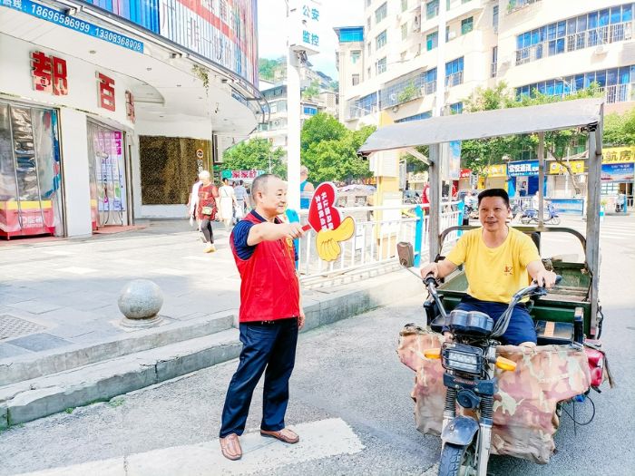 梓潼街道志愿者在斑马线前文明劝导。
