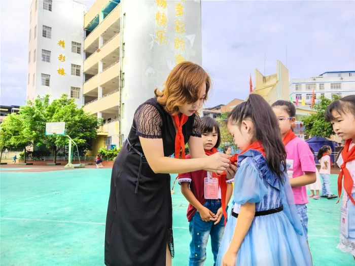 夏桂兰为少先队员整理红领巾。
