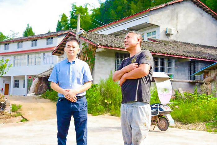 李世强（左）向村民陈廷烈征求村集体经济发展意见。
