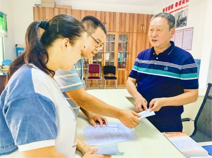 黄堡村支部书记周长生（右）和村干部一起交流党建工作。
