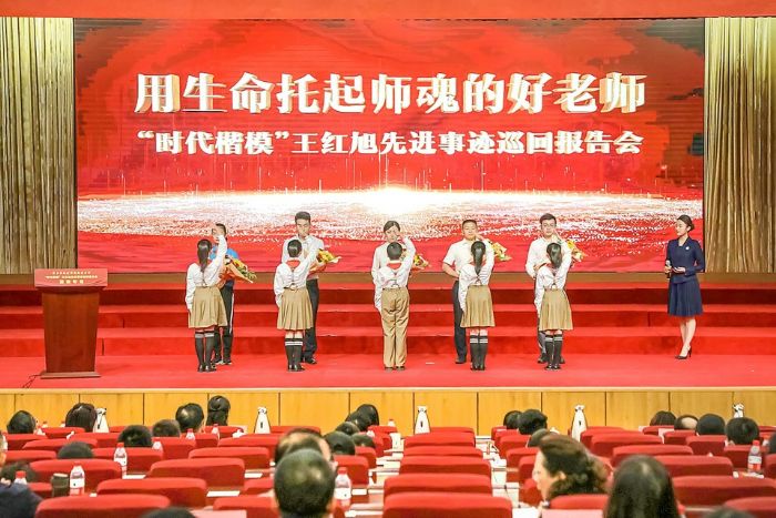 少先队员为五位报告人献花。
