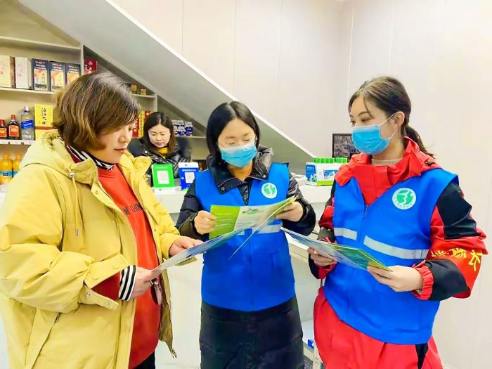 志愿者向商户发放“门前三包”告知书。