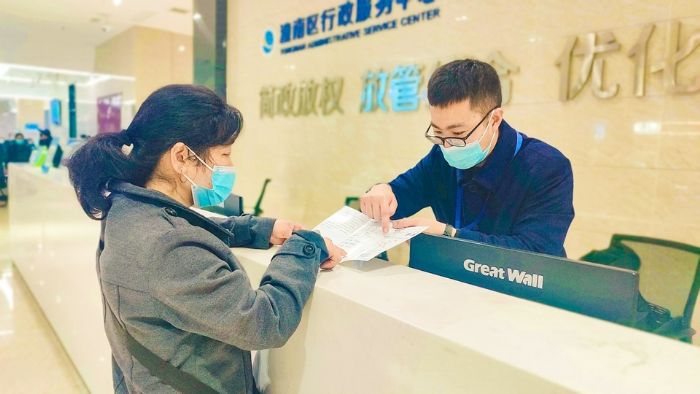 工作人员向市民介绍自助服务指南。
