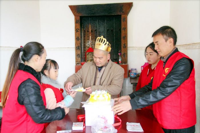 谭必伟家庭陪伴残疾老人庆祝生日。
