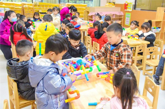 小朋友们在幼儿园玩搭积木。
