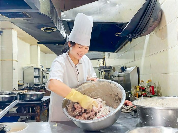 彭建芬给鱼拌豆粉。

