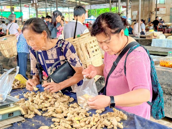 居民在菜市场选购生姜。
