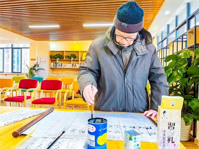 老人在活动室练习毛笔字。（资料图片）
